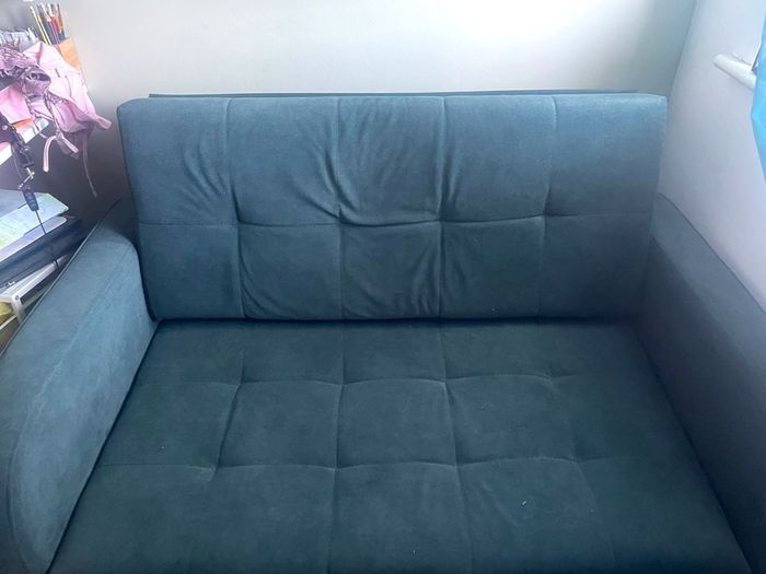 Grey fabric sofa bed with large storage compartment.
