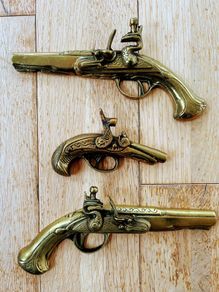 Three vintage brass pistols