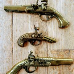 Three vintage brass pistols