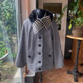 black and white short jacket with detachable faux fur scarf detail and cape sleeves.