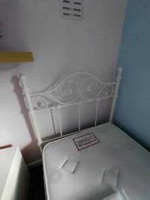 white metal single bed with mattress.