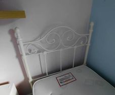 white metal single bed with mattress.