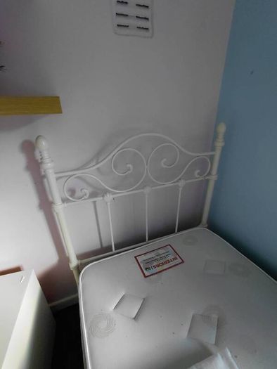 white metal single bed with mattress.
