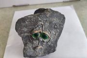 Face rock with green eyes hand carved