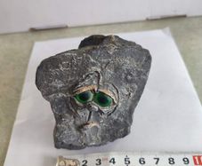 Face rock with green eyes hand carved