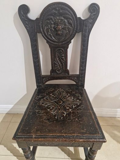 Carved oak antique chair with lion face motif