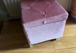 pink velour covered stool with interior storage space moves easily on castors