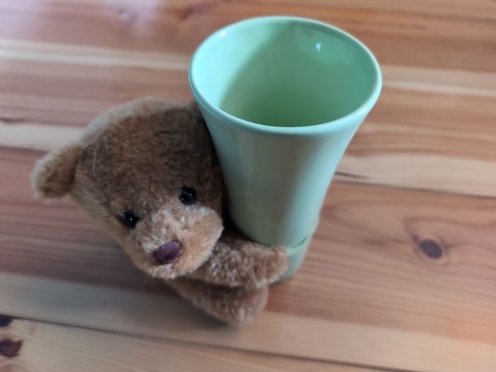 light green ceramic vase with teddy bear