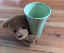 light green ceramic vase with teddy bear