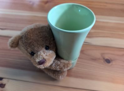 light green ceramic vase with teddy bear