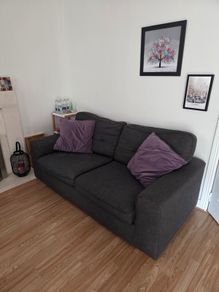 Charcoal Grey Sofa and two purple cushions