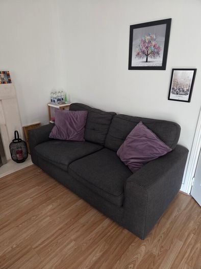 Charcoal Grey Sofa and two purple cushions