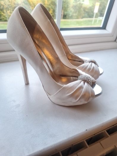 Ivory satin peetoe high heel shoes by Dune London with a pleated bow trim accented with rhinestones