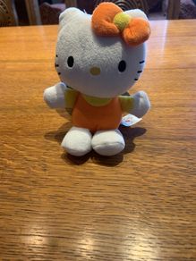 Hello Kitty plush toy in orange and yellow