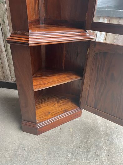 A tall mahogany corner cabinet.