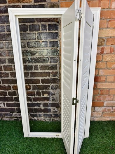 Vintage-style louvered white internal window shutter