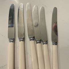 6 matching vintage Sheffield stainless-steel table knives with cream/ivory-coloured handles.