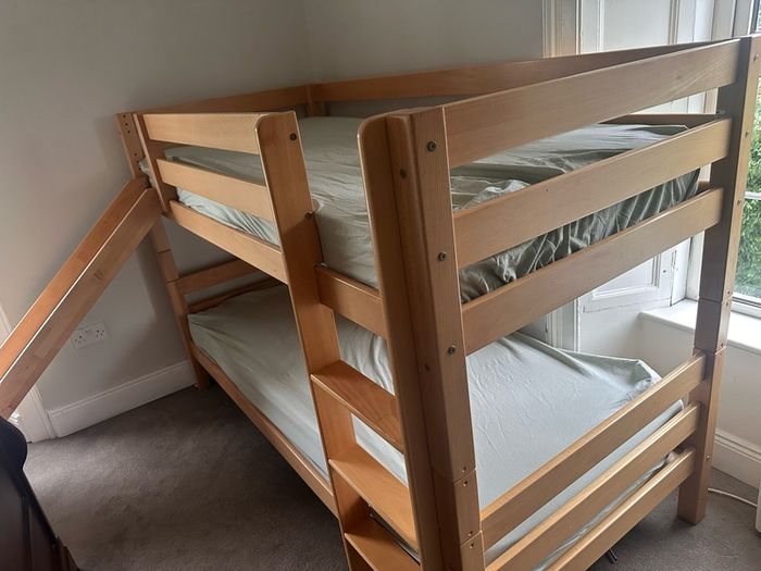 Bunk bed with attached slide and mattresses
