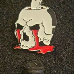 Skull, pin back badge.