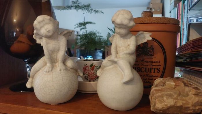Lovely Vintage Pair of Ceramic Baby Winged Angels Sitting on Globes with a Very Tactile Cream Coloured Crackle Glaze
