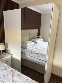Large white wardrobe with mirrored sliding doors.