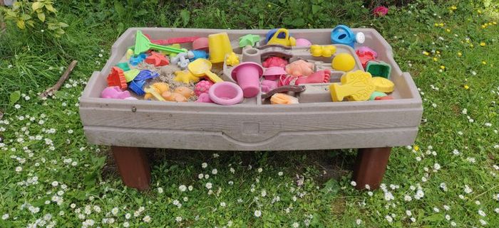 Sandbox with lid and bunch of sand toys.