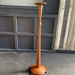 An early 20th century Art Deco oak candle holder with brass top. 122cm