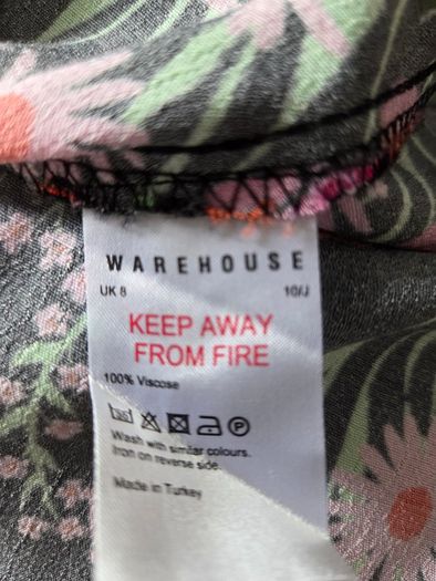 New. Warehouse Size 8 Black Floral print dress with frill trim.