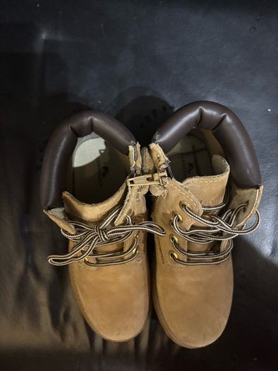 pair of tan/wheat leather boots with a padded dark brown collar.