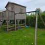 Wooden playhouse with slide and swings Image 3