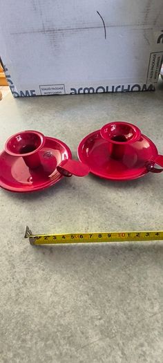 Set of 2  Red enamel candlestick holder and drip tray featuring a Considered by Helen James 12.00 euro each.