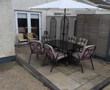 garden table with six chairs and parasol