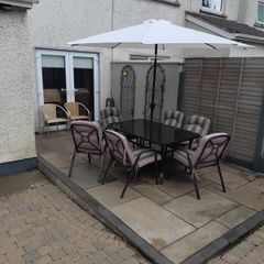 garden table with six chairs and parasol