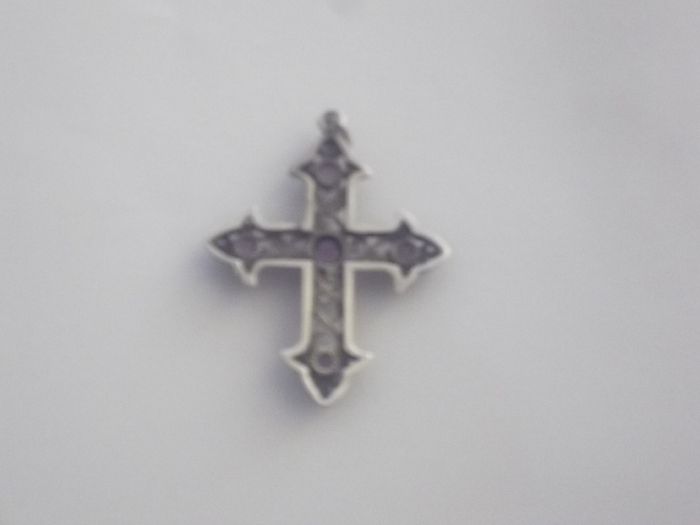 a vintage  solid silver cross penden  with 5 pink stones on it
