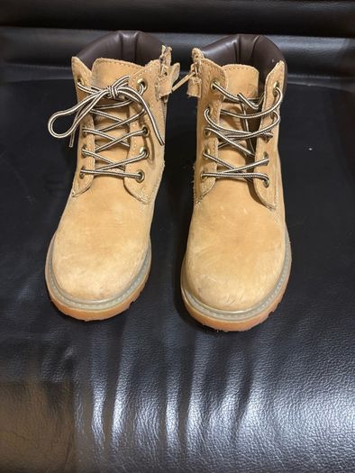 pair of tan/wheat leather boots with a padded dark brown collar.