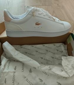 Brand new white Lacoste sneakers with blush pink suede heel detail and signature gold crocodile logo. Classic low-top design with white laces and chunky sole for everyday comfort. Never worn, in perfect condition, and comes with original box. Stylish, cle