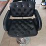 2 black faux leather bar stools with padded seats, armrests and chrome bases. Image 3