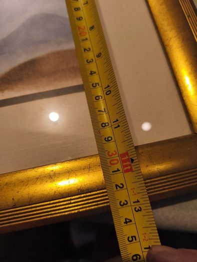Gold framed picruer of land scape.