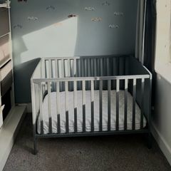 Grey cot with mattress