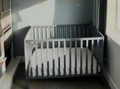 Grey cot with mattress