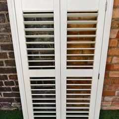 Vintage-style louvered white internal window shutter