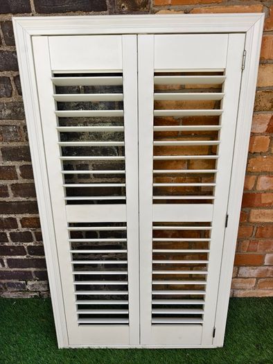 Vintage-style louvered white internal window shutter