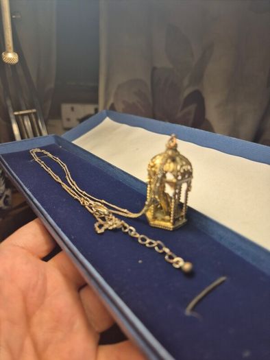 Vintage gilded bird cage with a bird pendant.