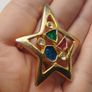 A gold star-shaped brooch. Image 5
