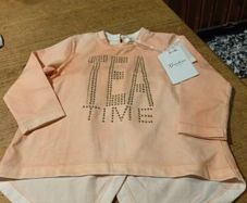This is a Gaialuna peach-colored long-sleeve top featuring "FREE TIME" embellished in studs on the front. New with tags..