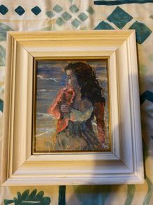 painting This is an atmospheric portrait depicting a woman standing on a coastal shore at dusk or twilight, clutching a reddish-pink wrap or cardigan around her shoulders.