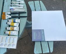 Paints, brushes, knives, and a canvas board