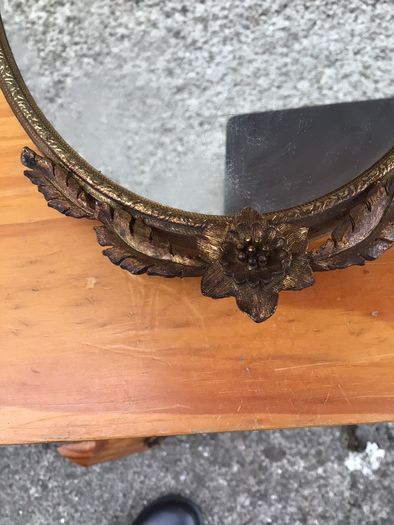 Brass framed ornate oval mirror