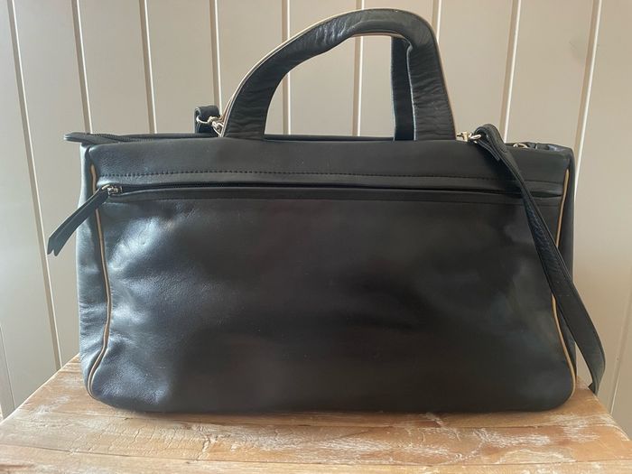 Tula black leather tote bag with a shoulder strap.