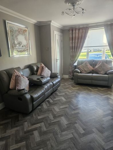 Grey leather recliner sofa set with pink curtains